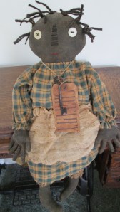 20" Mavis is weighted to sit anywhere. She has a grubby tag with the word "SIMPLIFY" and an old key on dirty string around her neck. $43.00