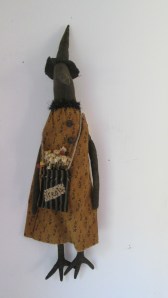 Matilda the crow is 23" tall to the tip of her hat and is designed to hang. Her pocket (which hangs from jute around her neck) has "Treats" hand-stitched on the front and is filled with dried flowers and artificial bittersweet. $39.00